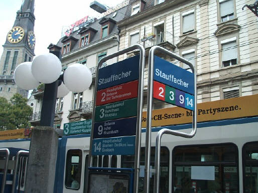 TRAMHALTESTELLE STAUFFACHER. Mit 3er Tram. VBZ Züri-Linie. Tram Nummer 3, Modell Tram 2000. Links im Bild die Kirche St. Jakob am Stauffacher.